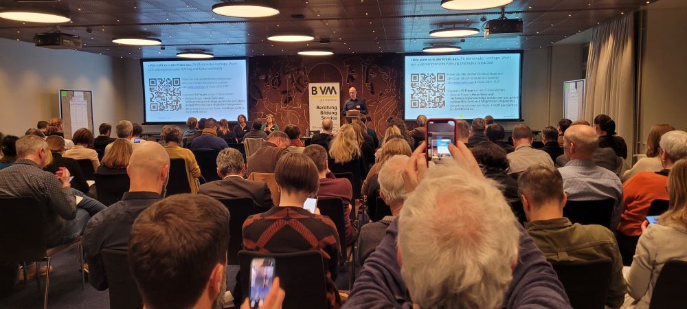 Menschen sitzen in einem Saal. Sie nehmen teil am Netzwerkanlass von B'VM und VMI