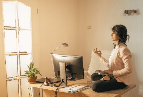 Frau macht Yoga auf dem Bürotisch