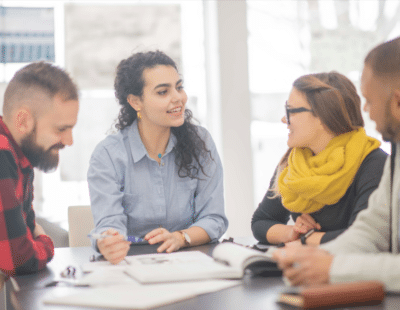 Vier Personen besprechen etwas miteinander